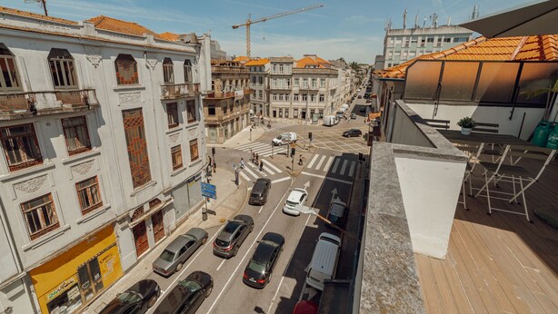 Vista da rua com prédios, carros e uma guindaste de construção.