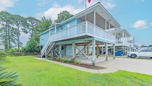 A two-story house with a porch and a flag. - Bear Point Bayview Cottage – Bay Views, Marina Walk (Orange Beach)