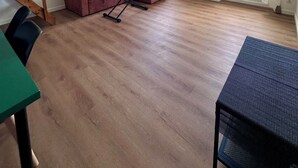 A spacious living area with a wooden floor, a red sofa, a small table, and a large mirror reflecting the room. - Appartement Cosy - Chartreux (Marseille)