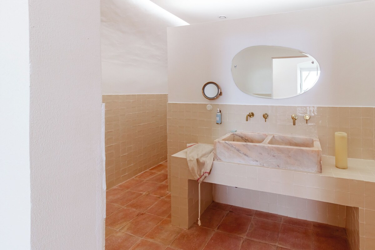 A bathroom with a white sink, a mirror, and a towel rack.