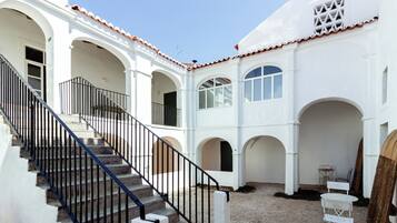 Un edificio blanco con una escalera y ventanas arqueadas.