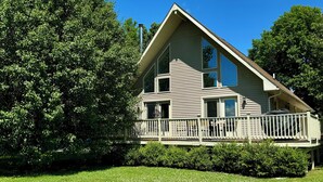 A two-story house with a large front porch and a covered deck.