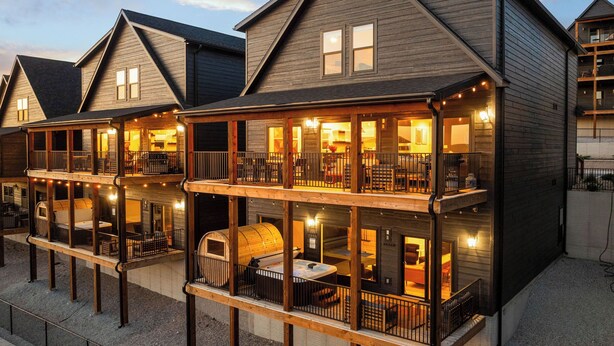 A multi-story wooden building with balconies, outdoor seating, and a barbecue area. - Branson GOAT: Golf Simulator Hot Tub Lake View Fun (Branson)