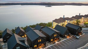 A lakeside hotel with multiple buildings, a parking lot, and a view of the lake. - Branson GOAT: Golf Simulator Hot Tub Lake View Fun (Branson)