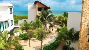 A resort with a beach view, palm trees, and a pathway leading to the ocean. - Corcomoran Luxury Beachfront house (Telchac Puerto)