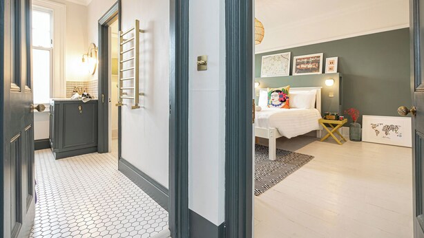 Une chambre d’hôtel avec un lit, une table de chevet et une vue sur le couloir.
