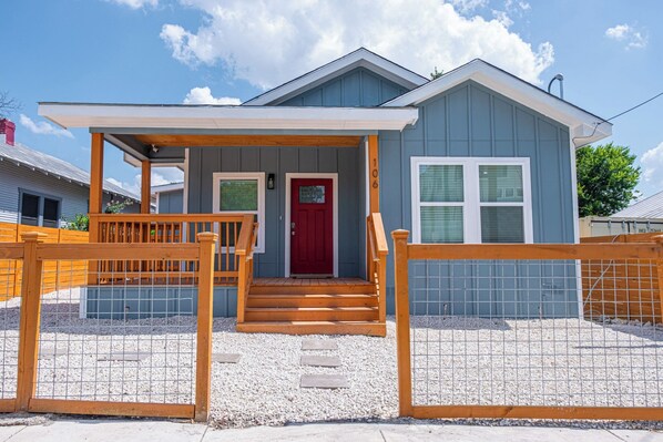 Stroll up to the welcoming porch, accessible via wooden steps, and enter a simple, functional home with a gabled roof.
