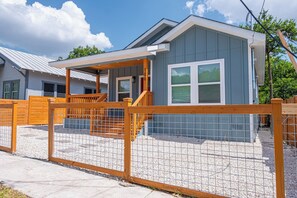 Stroll up to the charming single-story home with a covered porch and wooden railings.