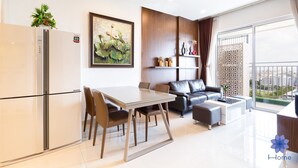 Una sala moderna con comedor, un sofá y un balcón con vistas.