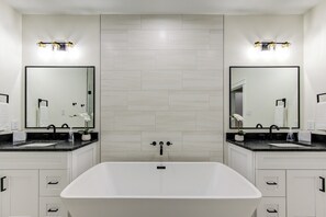 A modern bathroom with two sinks, a large bathtub, and a mirror above each sink. - Beautiful Luxury Villa near downtown and IAH (Houston)