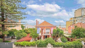 A building with a red-tiled roof, surrounded by greenery and a clear sky. - GuestReady - Bright escape near Santa Apolónia (Lisbon)