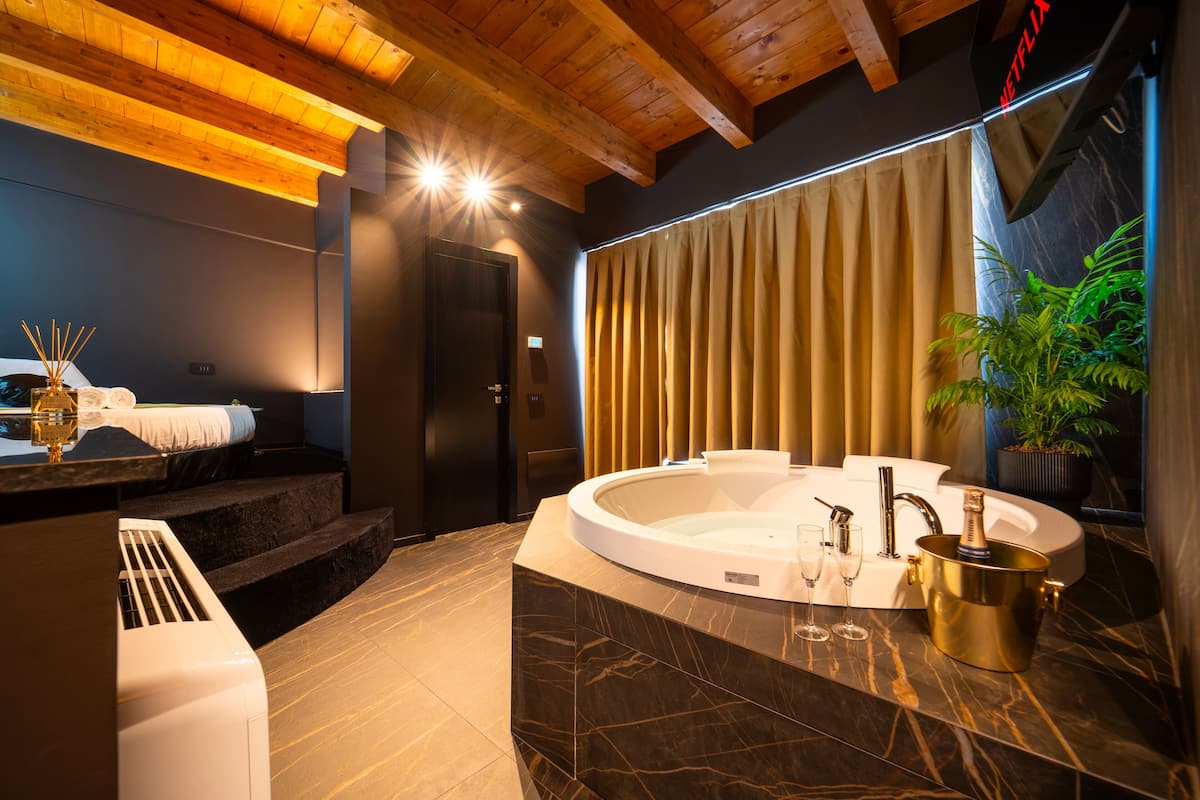 Ein modernes Badezimmer mit einer freistehenden Badewanne, einer großen Topfpflanze und einer Minibar.