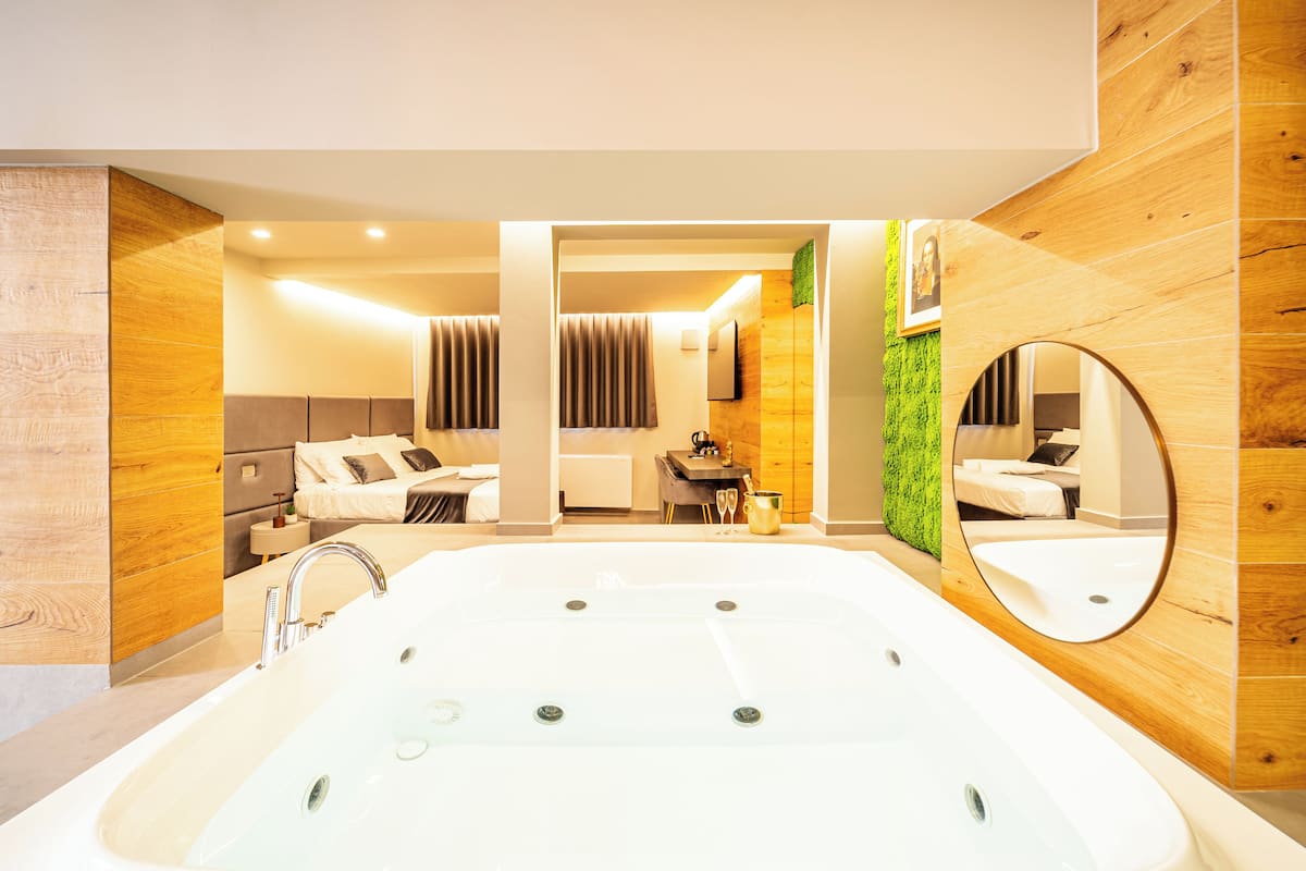 Ein modernes Badezimmer mit einer großen Badewanne, einem Spiegel und einer Holzvertäfelung.
