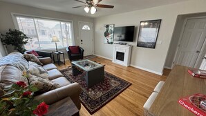 A living room with a sofa, coffee table, and a television. - Hot Stuff! Pro Cleaned Self Check In Sleeps 10 (Racine)