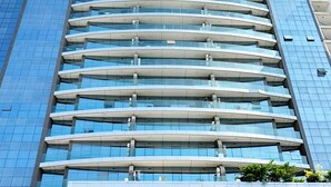 Ein modernes Hochhaus mit einer geschwungenen Fassade und mehreren Balkonen.