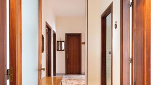 A hallway with wooden doors and a marble floor.