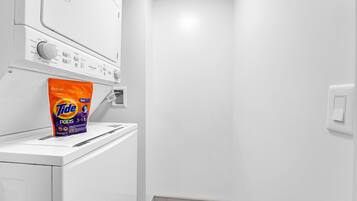 Un área de lavandería con Tide PODS 3-1-19 sobre una lavadora.