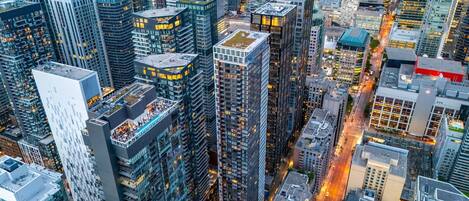 A high-rise urban area with modern skyscrapers, busy streets, and illuminated windows.