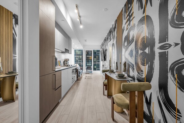 Una cocina moderna con una encimera amplia, armarios de madera y un comedor con mesa y sillas.