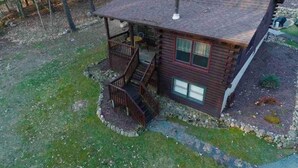 A log cabin with a porch and a chimney. - Cozy Fishing and Get-A-Way Cabin minutes from Lake George (Kattskill Bay)