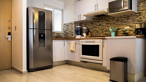 A modern kitchen with stainless steel appliances, a tiled backsplash, and wooden countertops. - New Apartment City Oasis In Roma Norte (Mexico City)