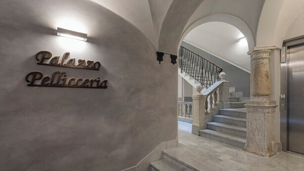 A marble staircase with a metal railing leading to an elevator.