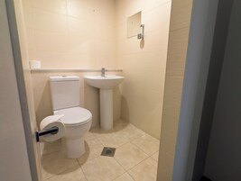 A small, clean bathroom with a toilet, sink, and a mirror on the wall.