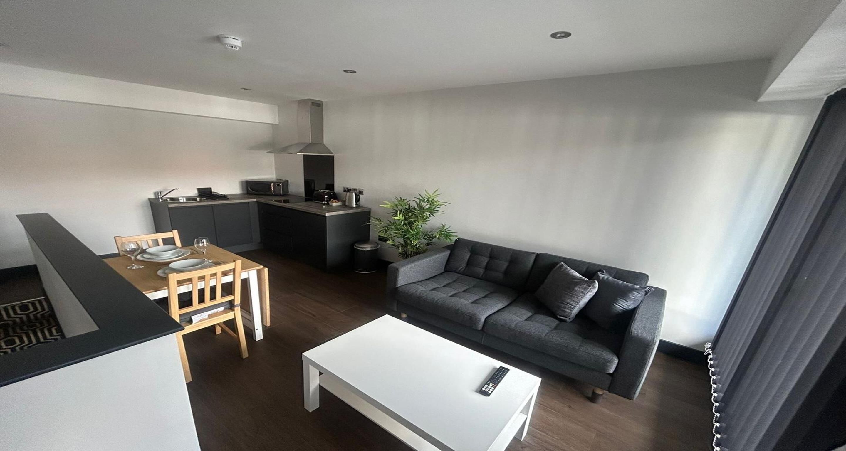 Un espace de vie compact comprenant une kitchenette, un coin repas et un coin salon.