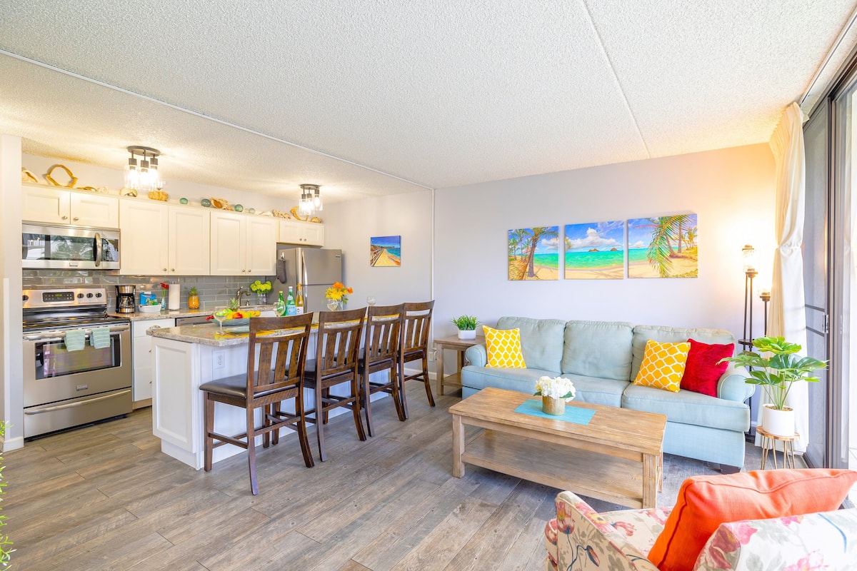 Une cuisine moderne avec des meubles blancs, des appareils en acier inoxydable et un coin repas doté de chaises en bois.