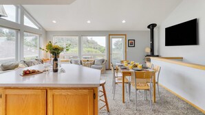 Una cocina amplia con una isla grande, armarios de madera y un comedor con sillas y una mesa.