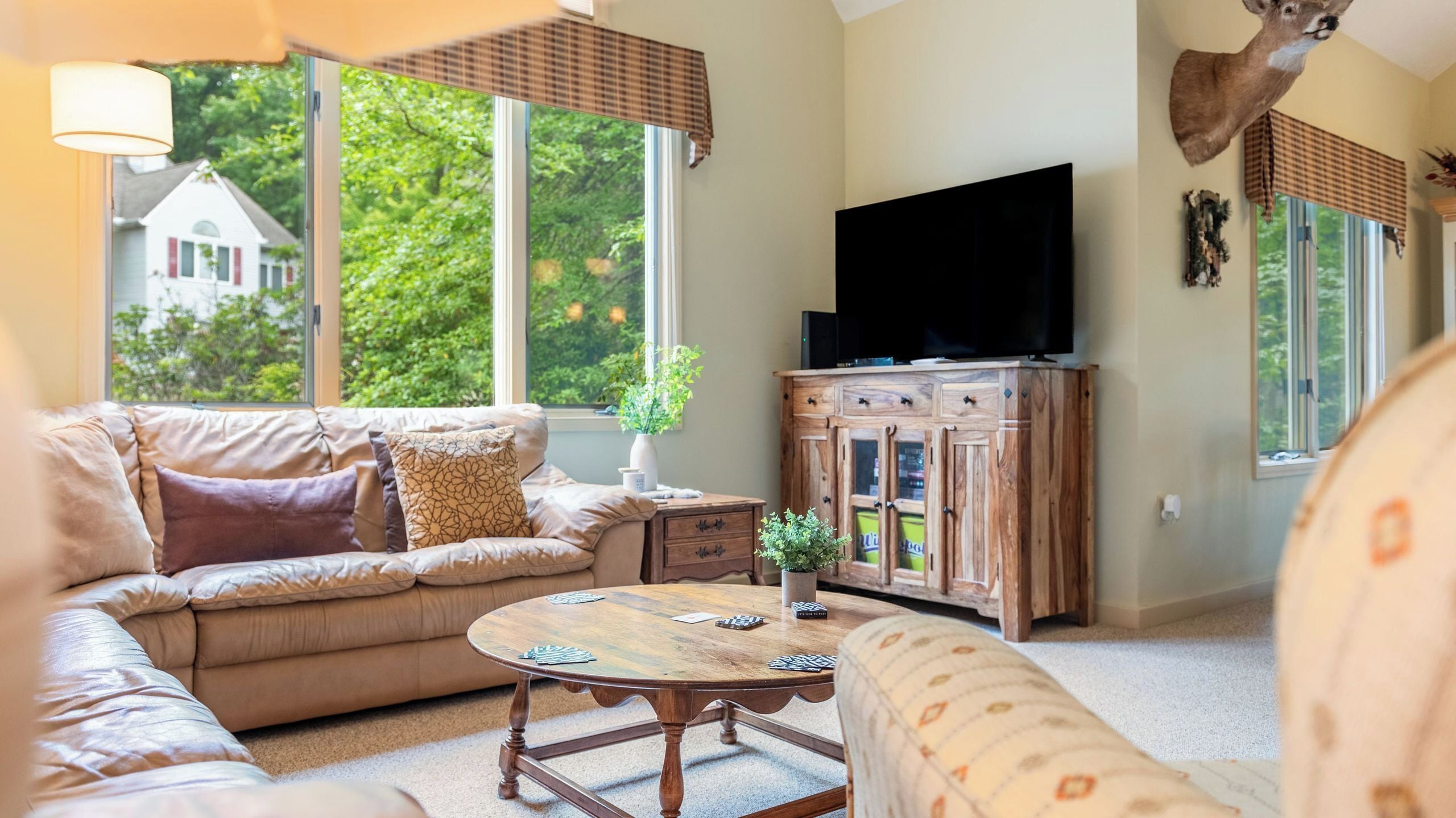 A living room with a sofa, a coffee table, a TV, and a wooden cabinet.