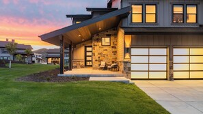 A modern house with a stone facade, a covered porch, and a garage. - Jordanelle by Avantstay Next to the Reservoir! (Heber City)