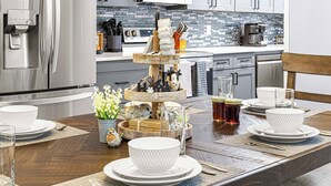 A modern kitchen with a wooden dining table set for a meal.