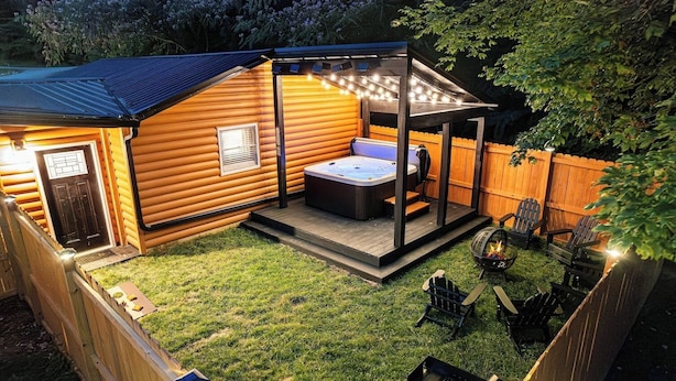 Eine gemütliche Außenpatio-Terrasse mit Whirlpool, Holzdeck und Sitzgelegenheiten.