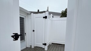 A wooden deck with a white fence and a door. - Central air, dog friendly walk to beach in this 2 bedroom family cottage  (Dennis)