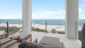 Uma varanda com vista para a praia e o oceano.
