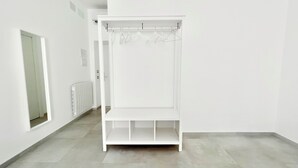 A white walk-in closet with a hanging rod and shelves.