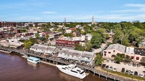 A waterfront cityscape with a marina, historic buildings, and a prominent church spire. - Riverwalk Retreat - Downtown water views, parking (Wilmington)