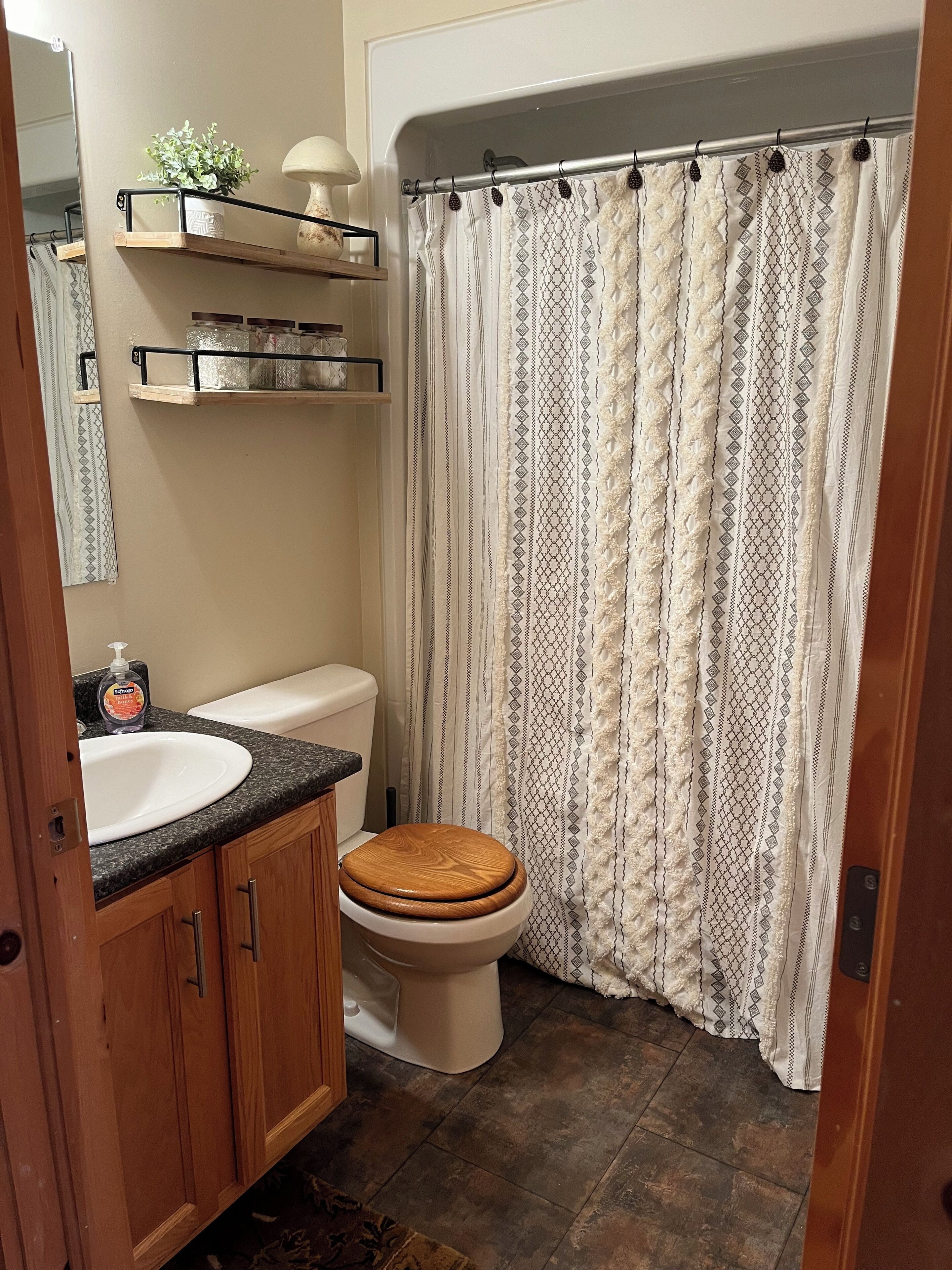 A bathroom with a toilet, a sink, and a shower curtain.