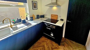 Una cucina compatta con lavello, fornelli e una finestra.