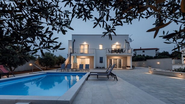 A modern two-story house with a swimming pool, outdoor seating, and a balcony. - Holiday Home Milutin 1 - Four Bedroom Holiday Home with Private Pool (Vrsi)