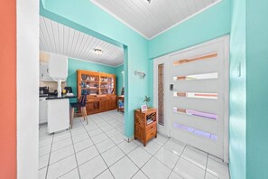 A kitchen with white cabinets, a wooden cabinet with glass doors, and a dining area with a chair and table. - Stunning Villa Near Beaches W/Pool 4Br&3Ba (Noord)