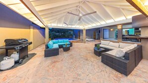 Un patio interior con piscina, asientos exteriores y ventilador de techo.