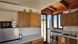 Une cuisine dotée de meubles en bois, d’un réfrigérateur en acier inoxydable, d’un four à micro-ondes, d’une cuisinière à gaz et d’un évier.