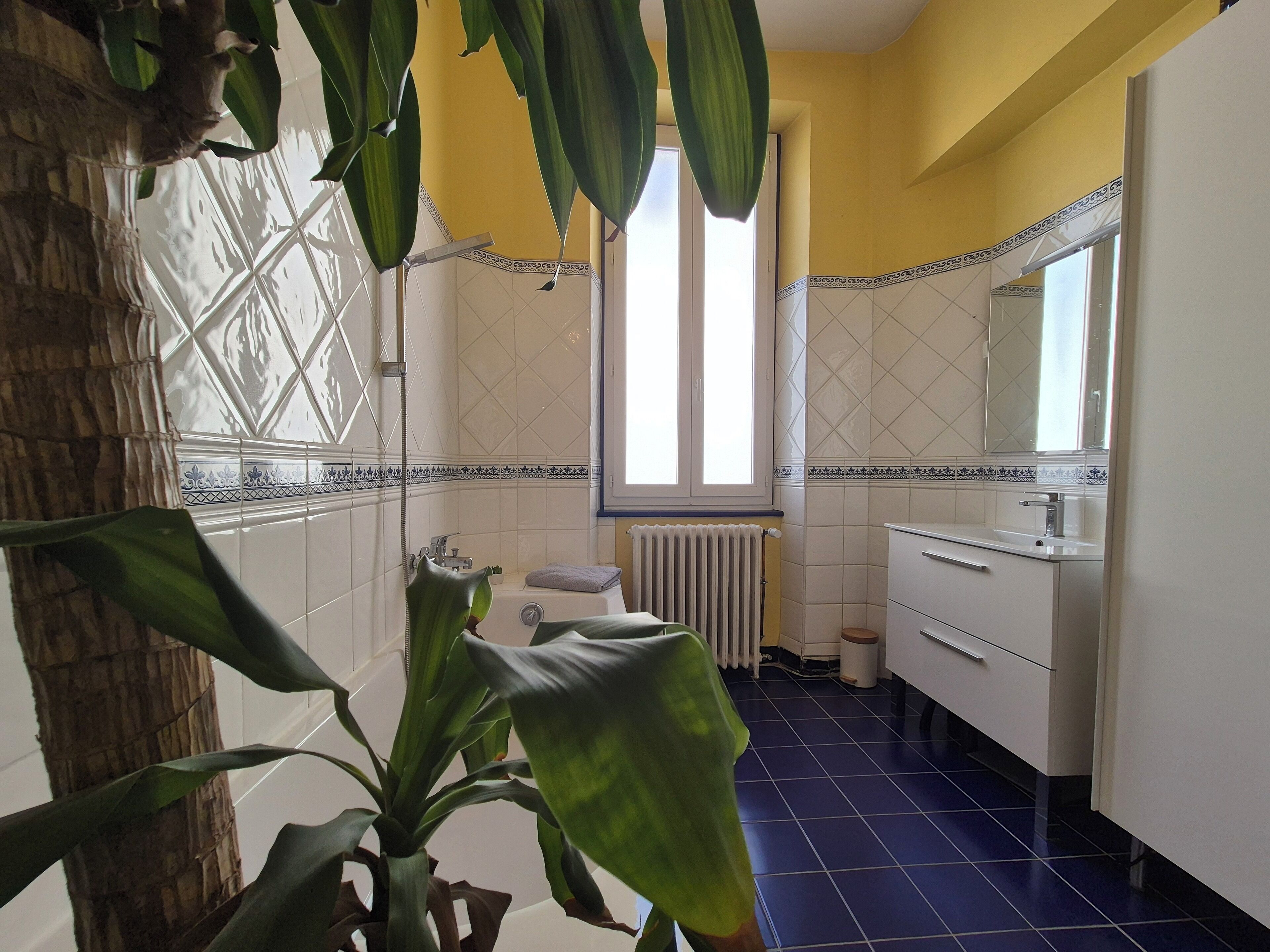 Une salle de bain avec une baignoire, une fenêtre et un lavabo.