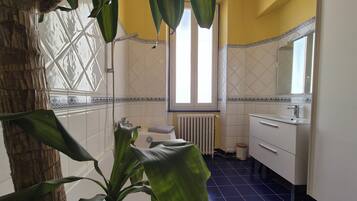 Une salle de bain avec une baignoire, une fenêtre et un lavabo.