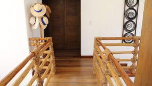 Eine Holztreppe mit Geländer und einer Tür am Obergeschoss.