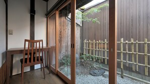 A traditional Japanese room with a sliding door, a wooden table, and a chair. - Takeya Tenmangu (Kyoto)