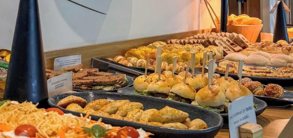 Un buffet proposant une variété de plats, notamment des sandwichs, des pâtisseries et des salades.