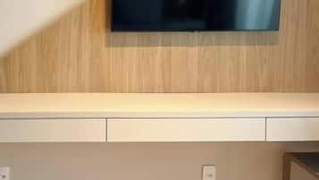 A flat-screen TV mounted on a wall with a wooden panel design.